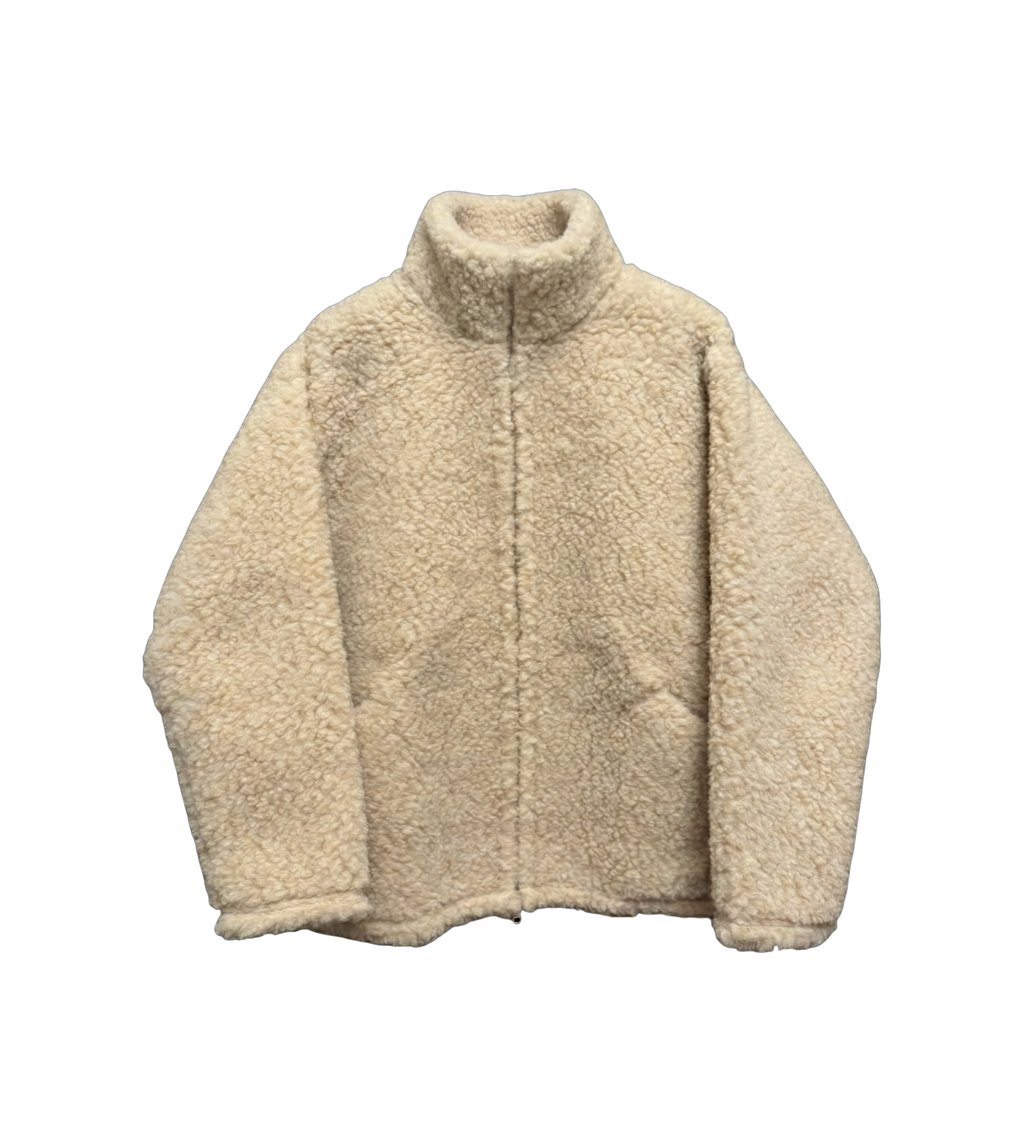 Wool Fleece Crafted from 100% tumbled wool, it offers a natural warmth and a textured hand that recalls traditional shepherd garments.